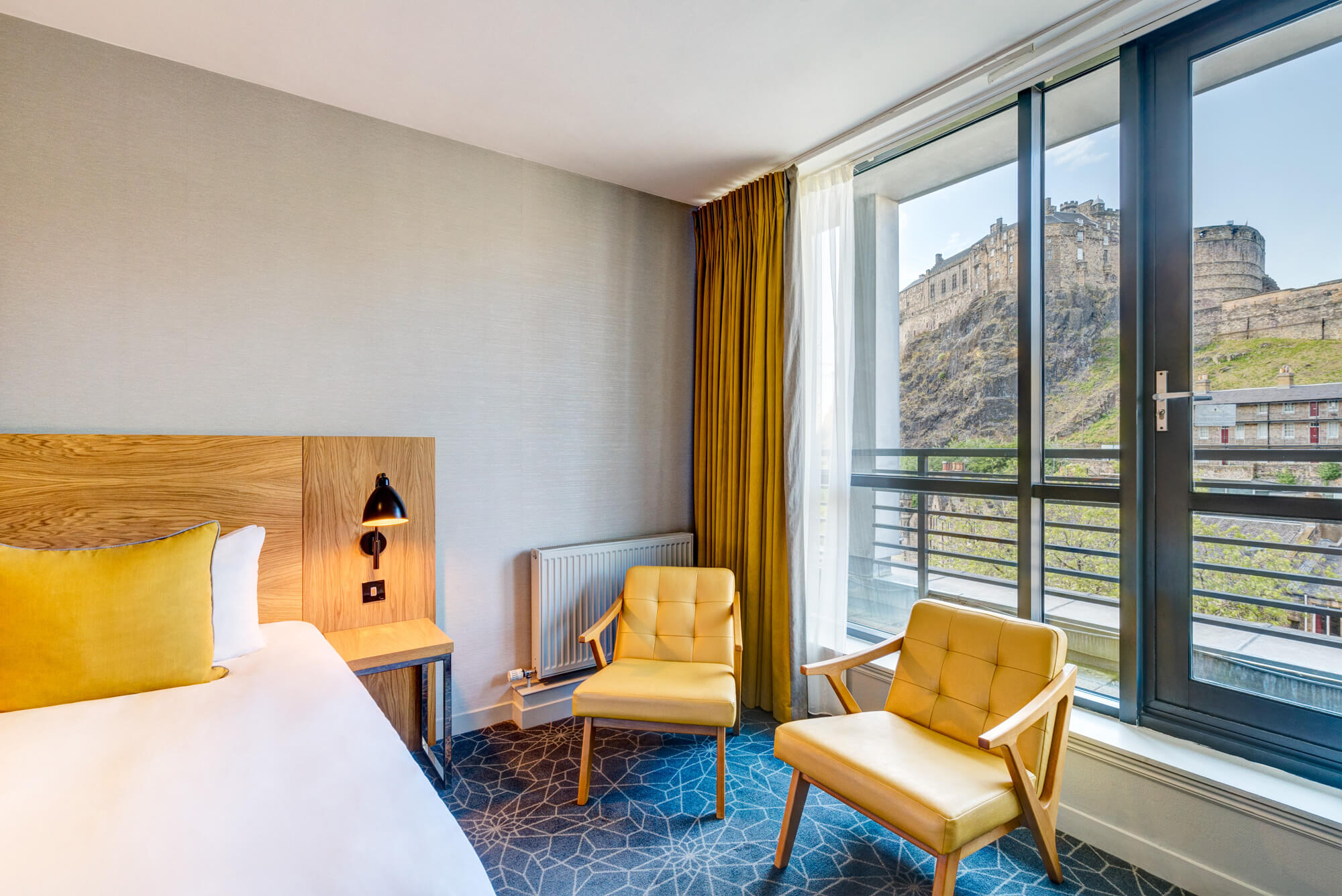 Double bed with views onto Edinburgh Castle in Apex Grassmarket's Deluxe Castle View Room