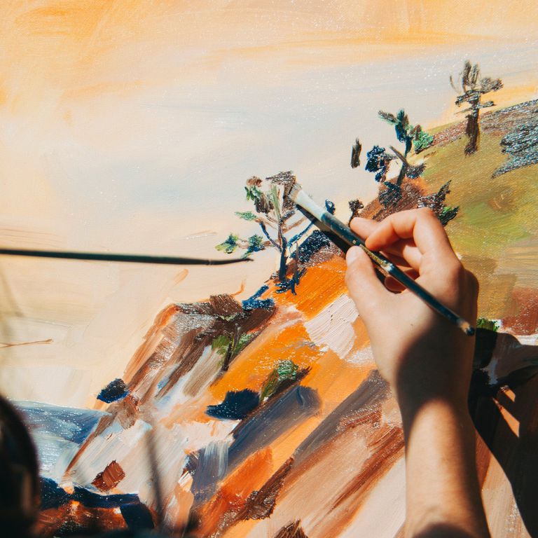 Woman painting a nature scene outside