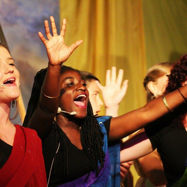 Women singing with hands in the air