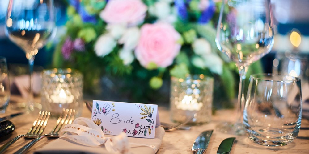 Bride placeholder on table set for wedding breakfast with flowers