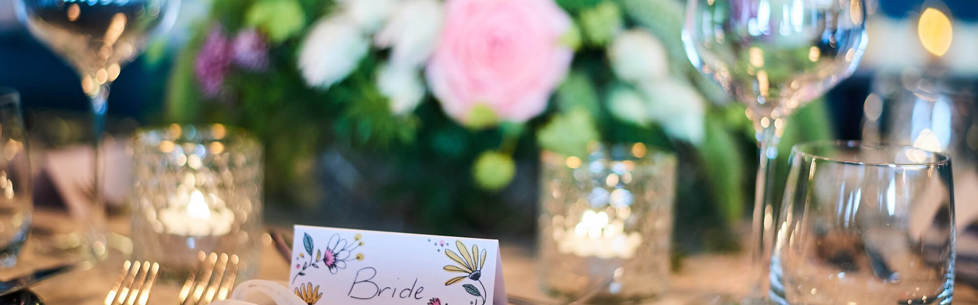 Bride placeholder on table set for wedding breakfast with flowers