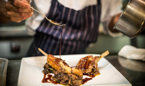 Chef plating up food on a plate Chef plating up food on a plate
