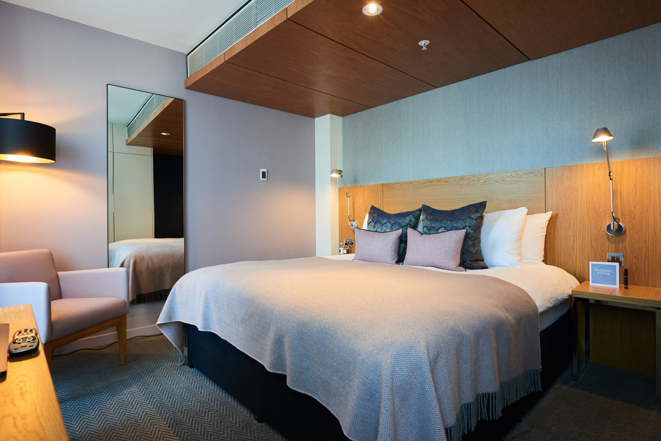 Junior Suite at Apex City of London Hotel Junior Suite bedroom with king-size bed and desk area at Apex City of London Hotel