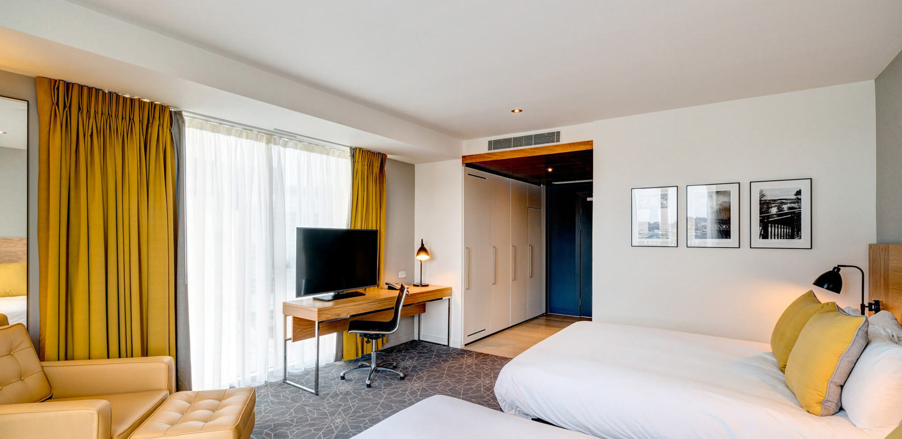 Family Room at Apex City Quay Hotel & Spa Family Room bedroom with two beds, armchair and desk