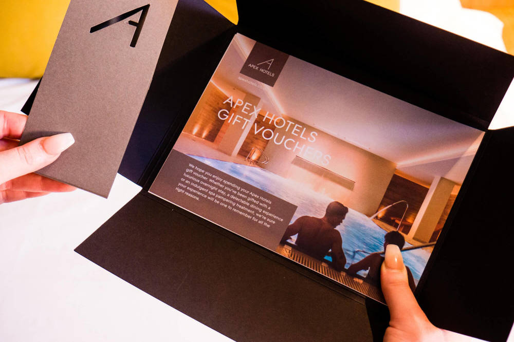 Apex Hotels Gift Voucher Hands holding an Apex Hotels gift voucher