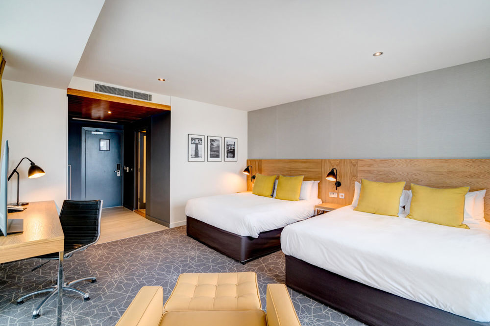 Family Room at Apex City Quay Hotel & Spa Family Room in Dundee with two beds, desk and armchair