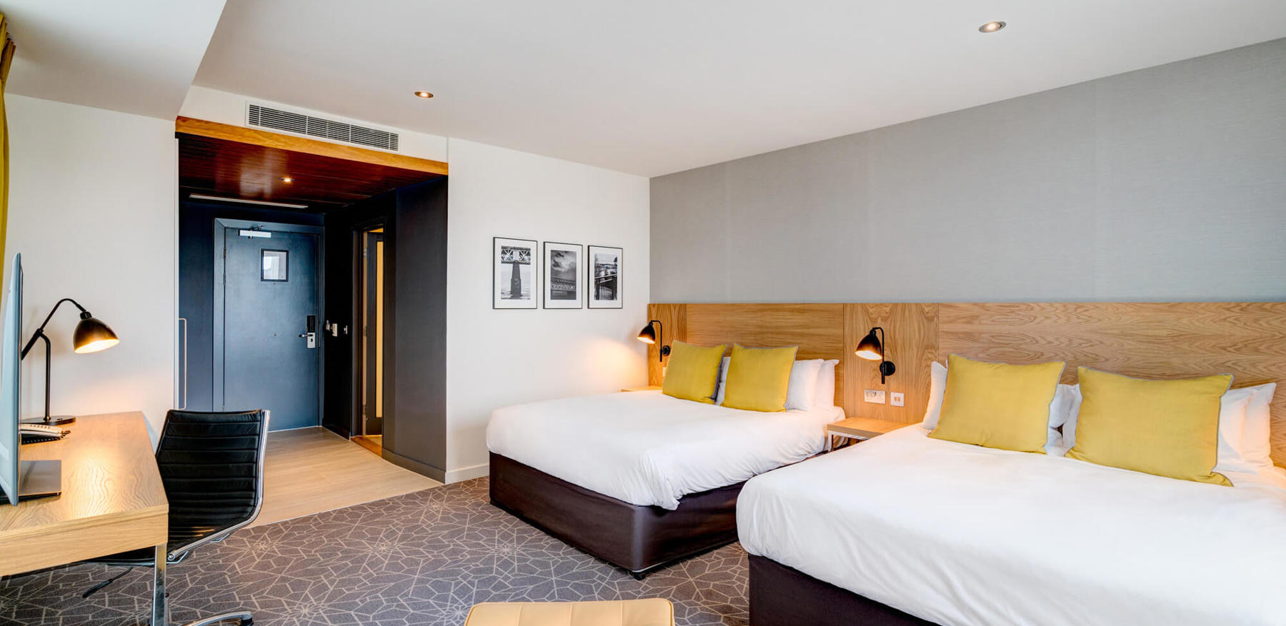 Family Room at Apex City Quay Hotel & Spa Family Room with two beds made up and desk area