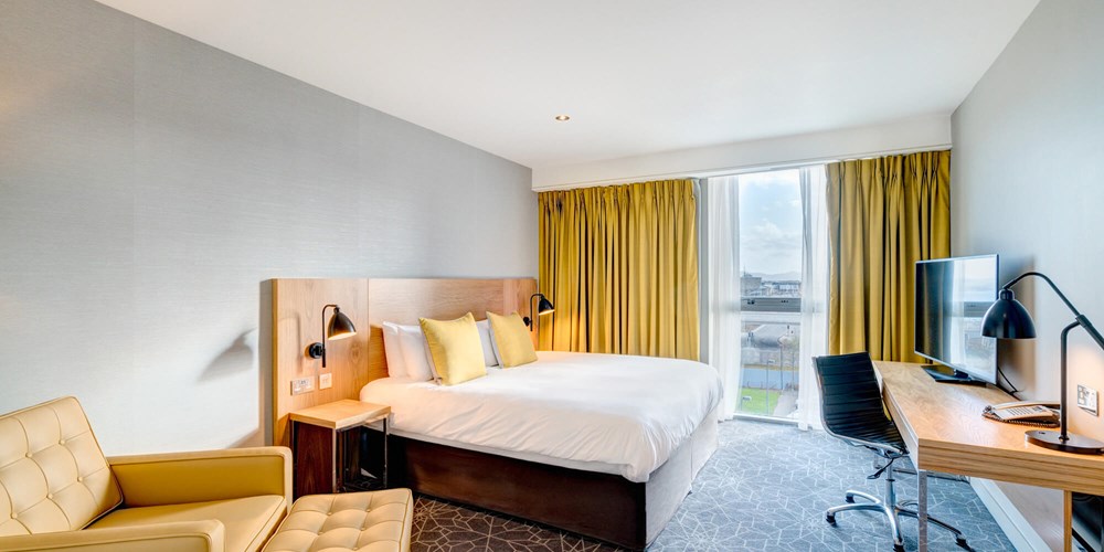 Apex City Quay Hotel City Bedroom with double bed, large desk and arm chair