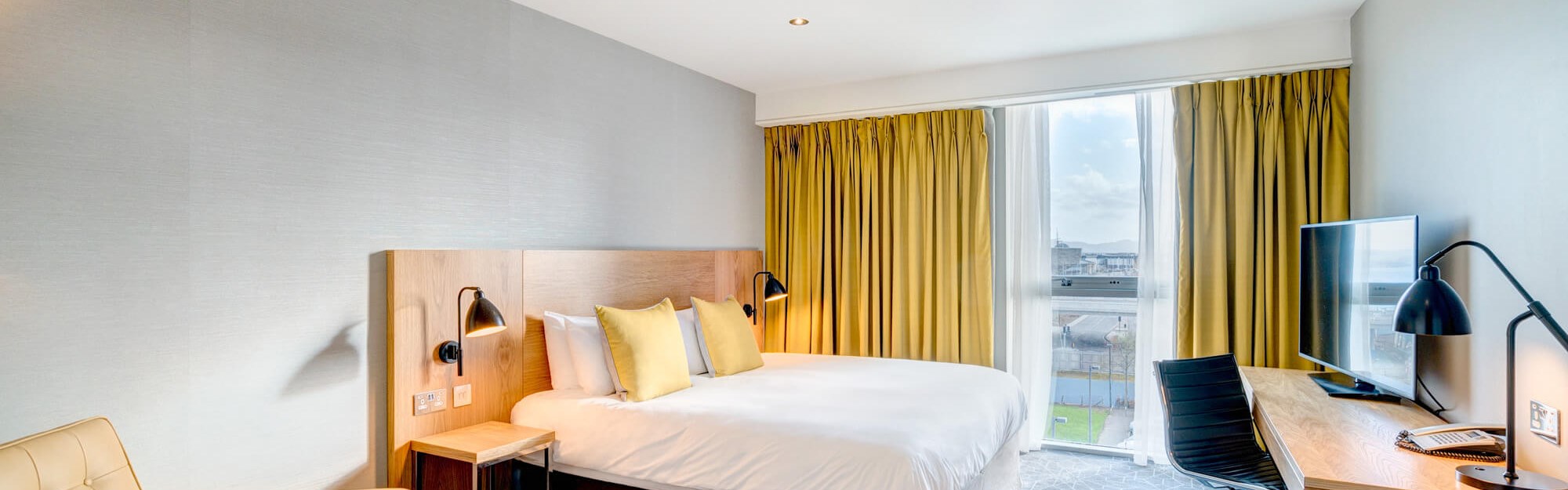 Apex City Quay Hotel City Bedroom with double bed, large desk and arm chair