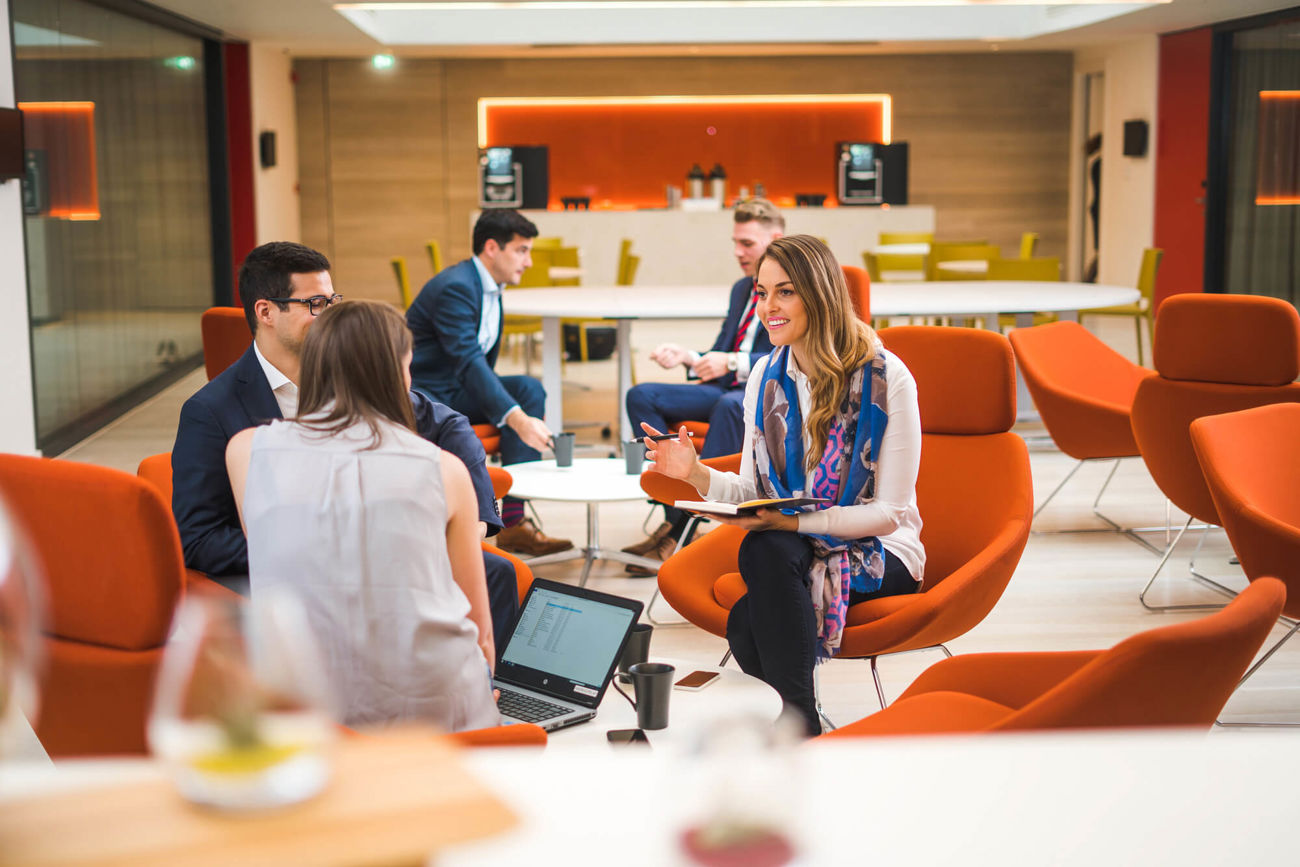 Colleagues sitting chatting in The Atrium at Apex City of Bath Hotel