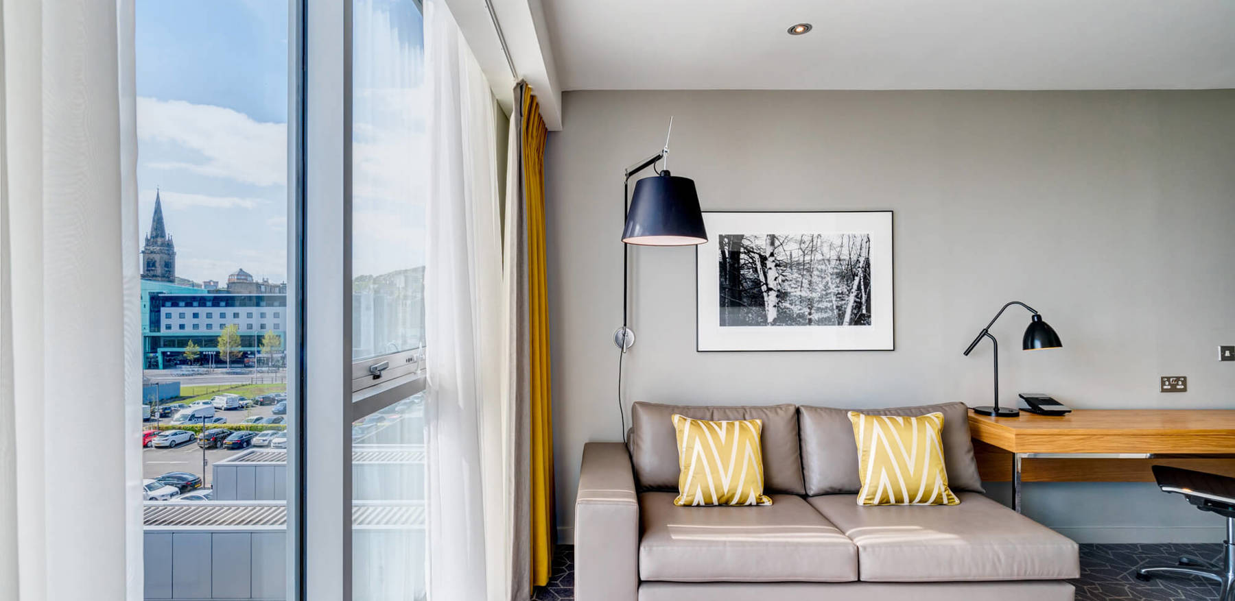 Junior Suite at Apex City Quay Hotel & Spa Junior Suite sofa and reading lamp next to window