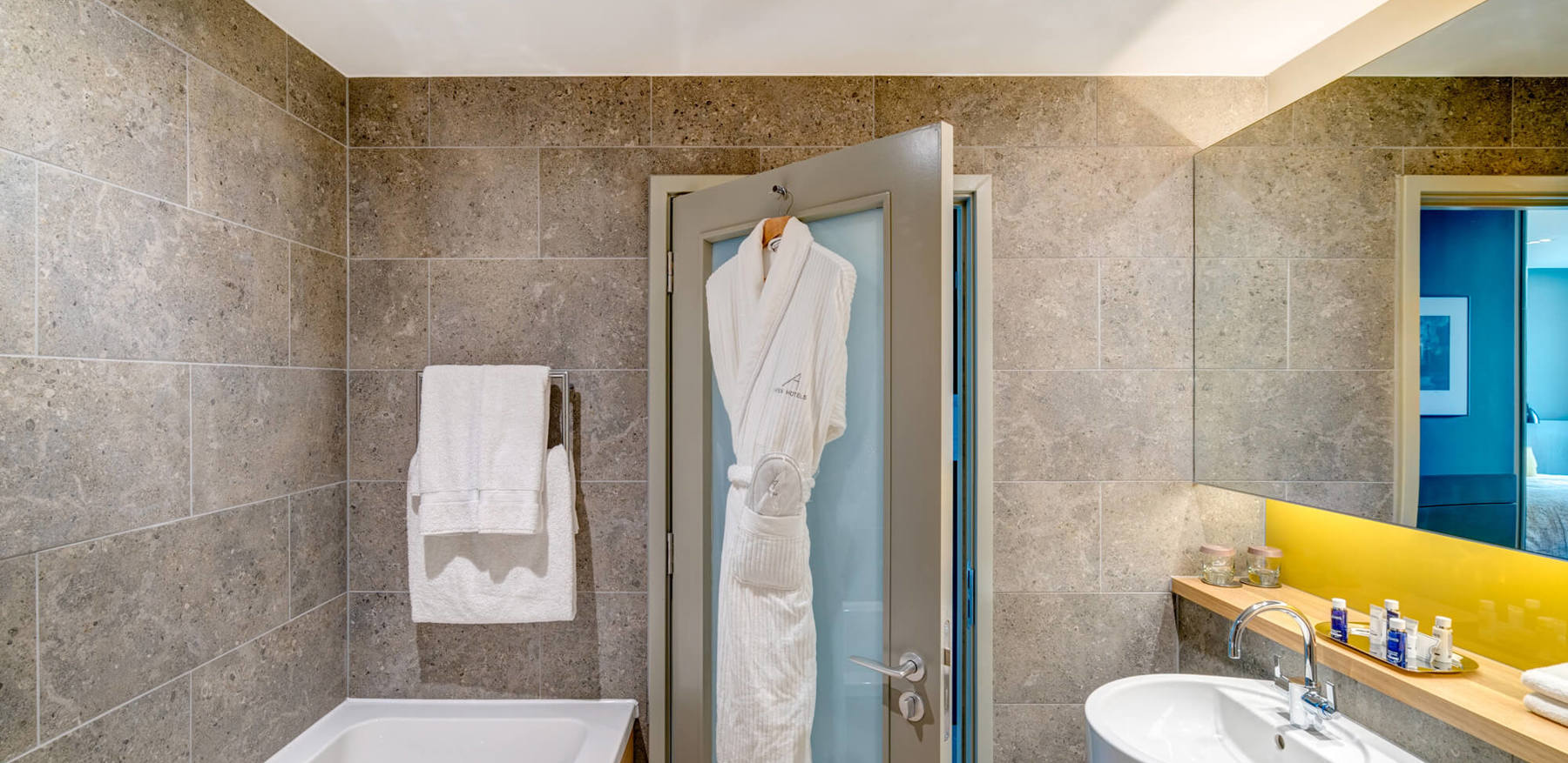 Deluxe Room bathroom at Apex City of Bath Hotel Deluxe Room bathroom with bath and robe hanging on back of door