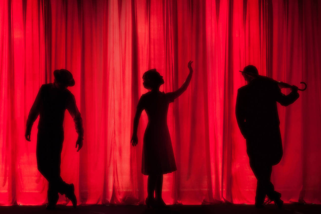 Dundee theatres Theatre performer shadows in front of red curtain