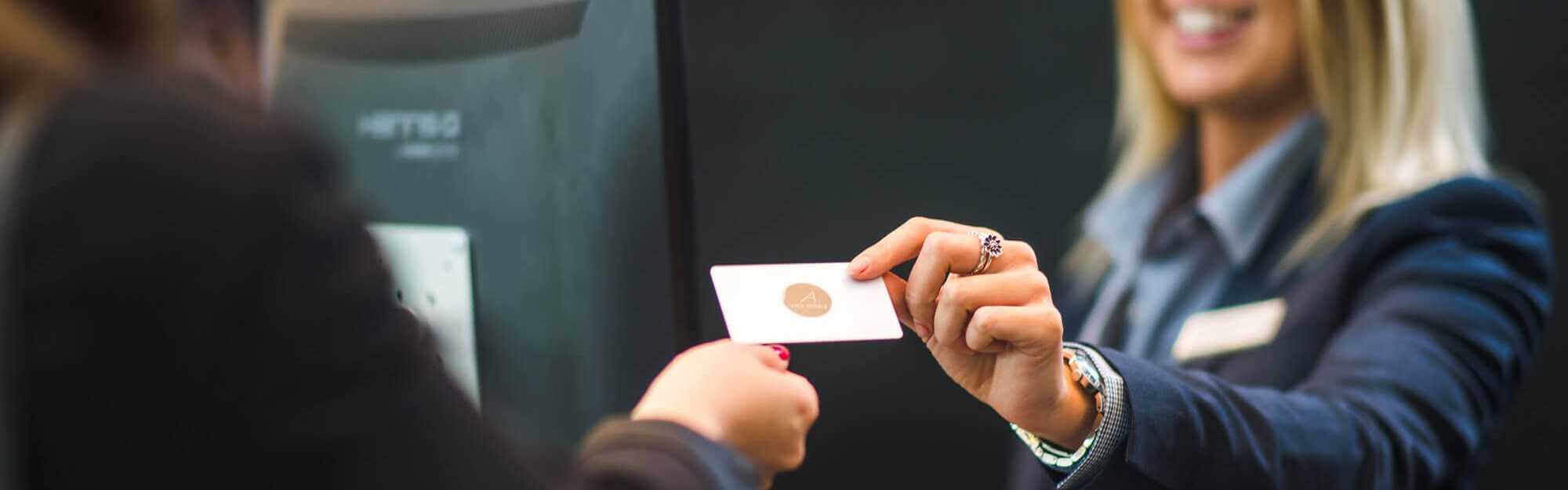 Female receptionist handing over a room key to guest
