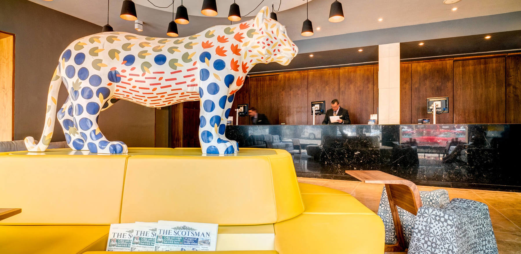 Reception area with ceramic tiger statue and yellow seats at Apex City of Edinburgh hotel in edinburgh old town