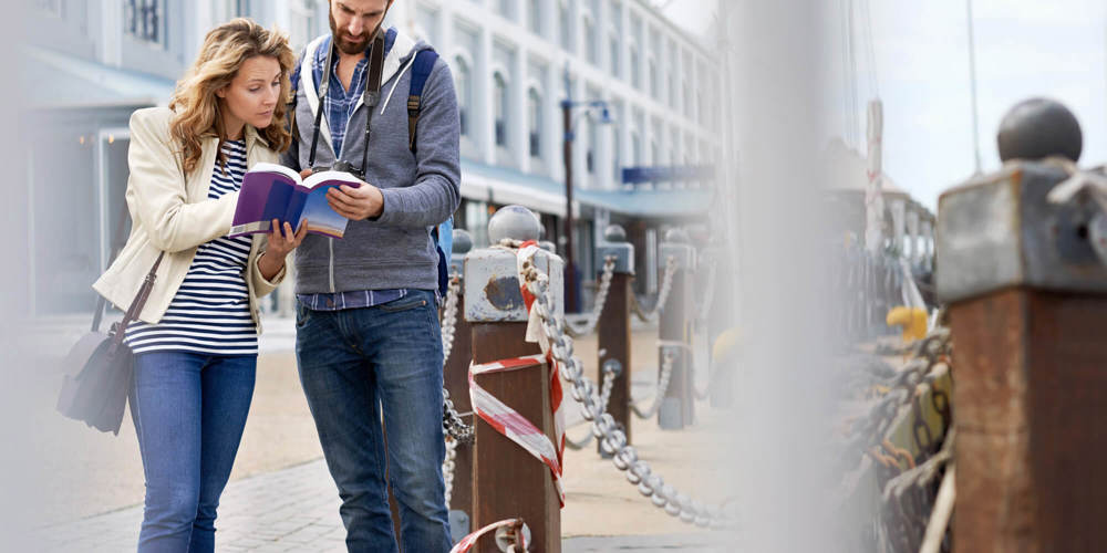 Explore new cities this winter Tourist couple looking at map