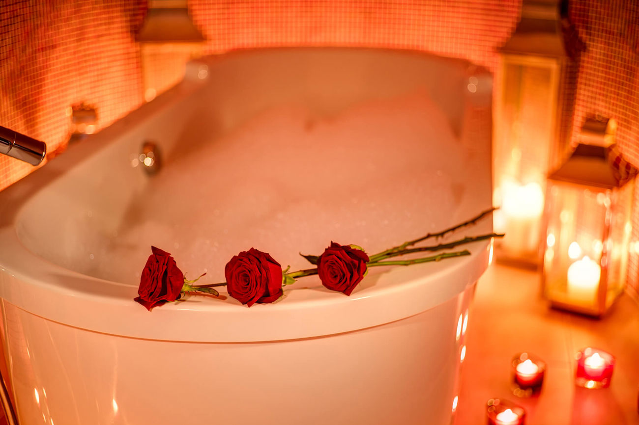 Bubble bath with candles and red roses